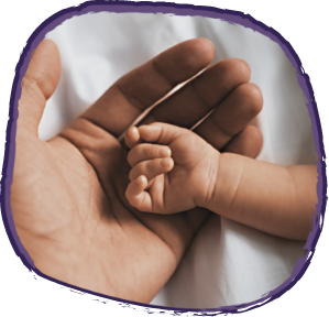 Babies hand within the palm of an adult’s hand