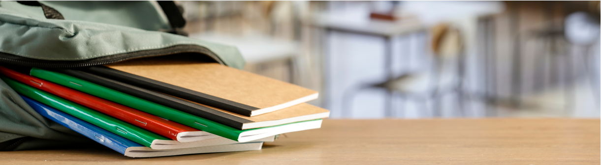 School books falling out a bag in a classroom